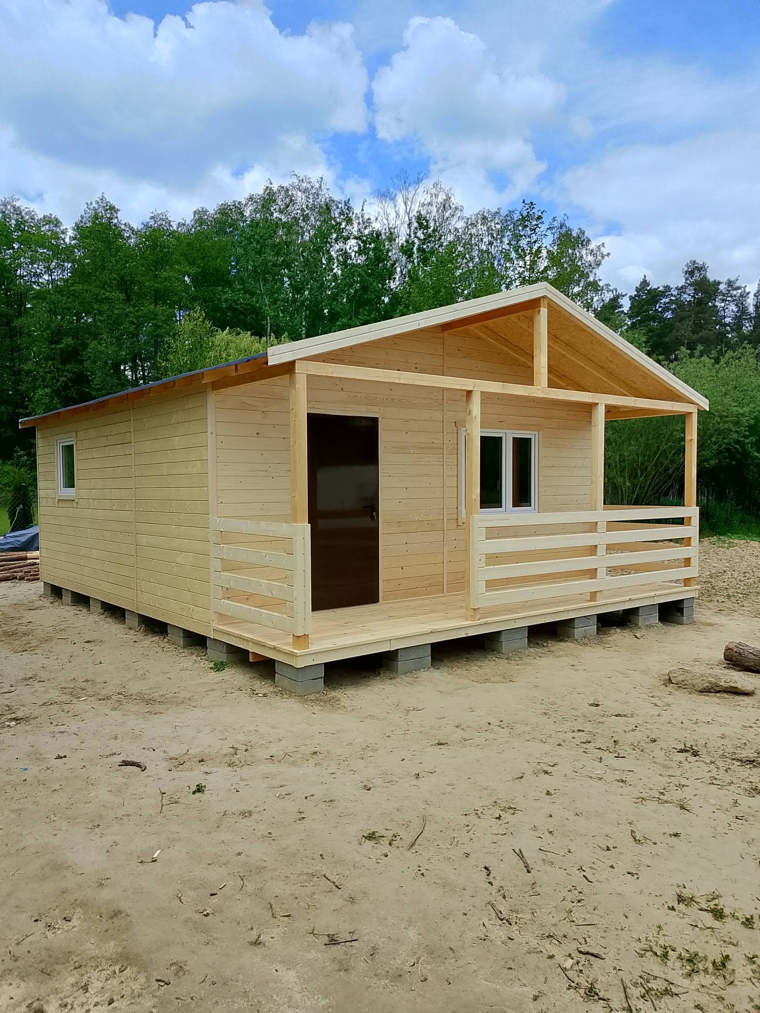 Kompaktowy drewniany domek letniskowy z gankiem