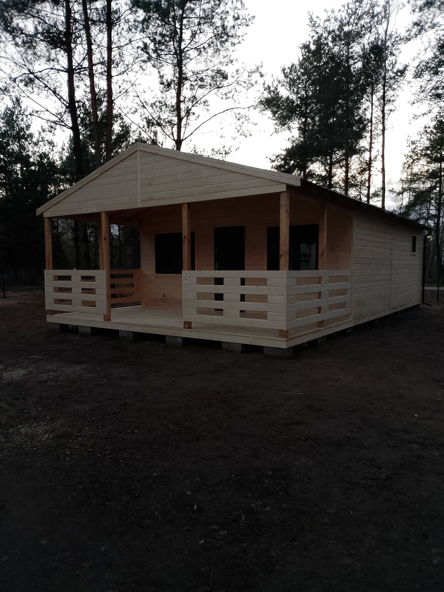 Drewniany domek z tarasem w leśnym otoczeniu