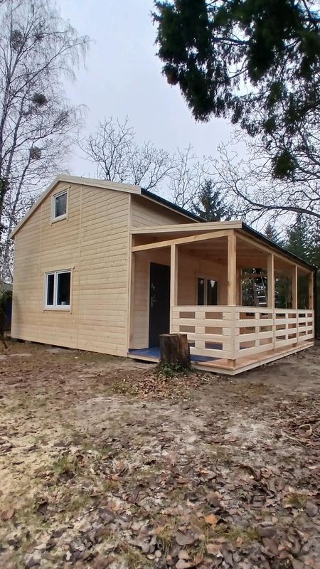 Piętrowy domek drewniany z zadaszonym tarasem - realizacja Pan Domek