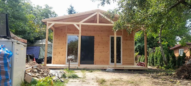 Domek drewniany z szerokim gankiem na działce - realizacja Pan Domek
