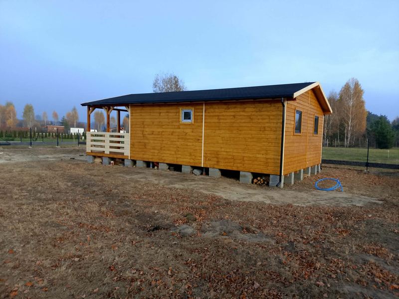 Długi domek drewniany z zadaszonym gankiem - realizacja Pan Domek