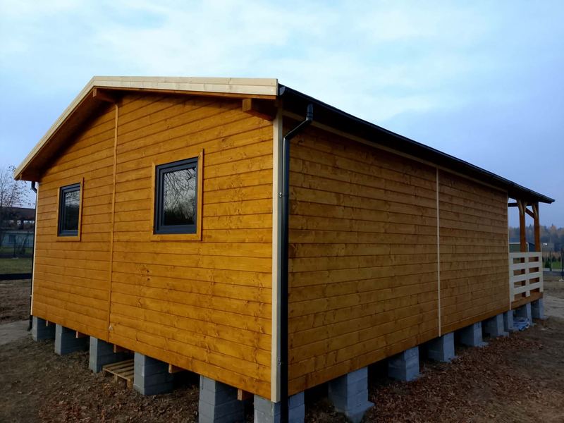 Drewniana elewacja domku z czarną stolarką - realizacja Pan Domek