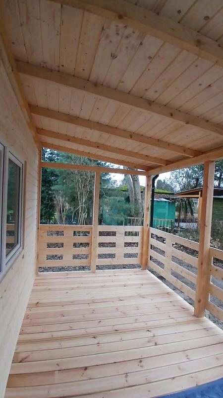 Zadaszony taras z drewnianą balustradą - realizacja Pan Domek